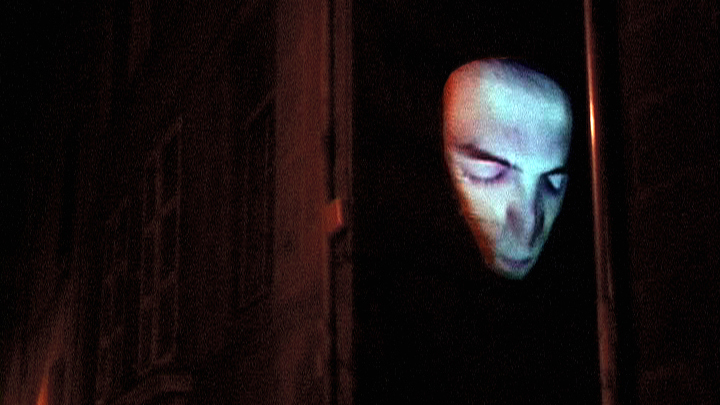 Visage projeté sur une façade, photo de l'installation de Sara Millot intitulée La nuit remue