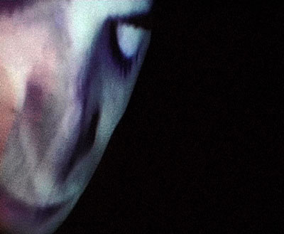 Visage projeté sur une façade, photo de l'installation de Sara Millot intitulée La nuit remue