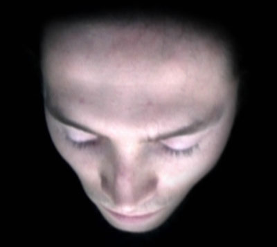 Visage projeté sur une façade, photo de l'installation de Sara Millot intitulée La nuit remue